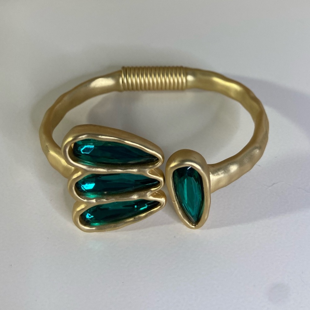Gold color bracelet with three green stones